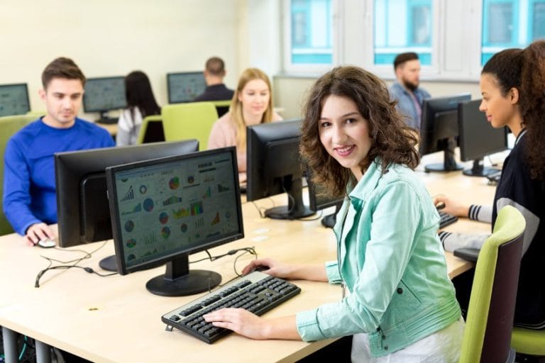 Équipe IT collaborant sur ordinateurs en open space
