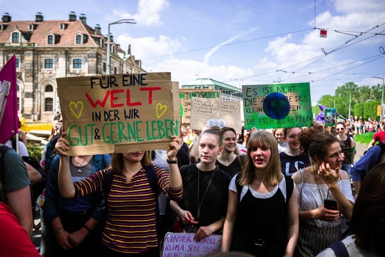 Jeunes femmes tenant pancartes "Welt in der wir leben"