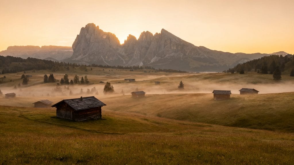 Alpage au lever du jour avec chalets et brume