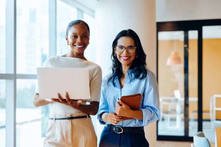 Deux professionnelles de cabinets RH souriantes avec laptop