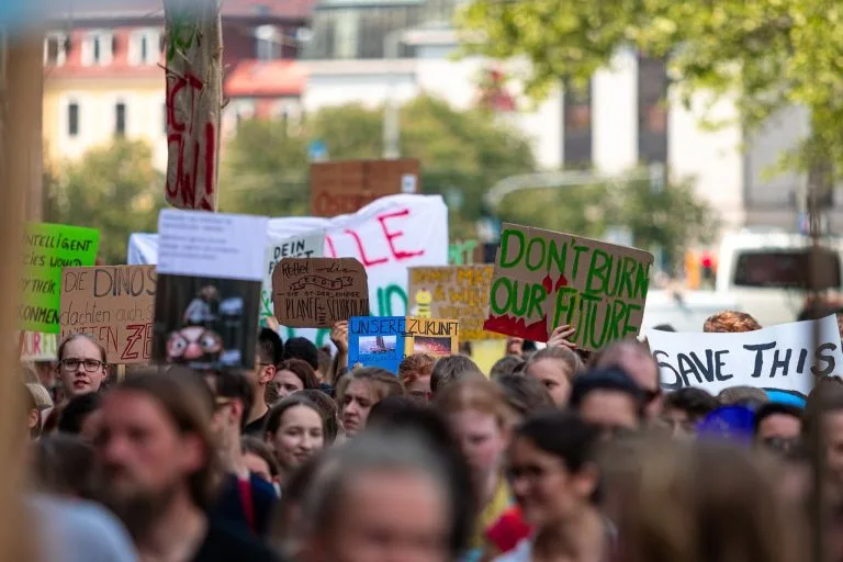 Manifestants jeunes avec pancartes écologiques lors d'une grève urbaine