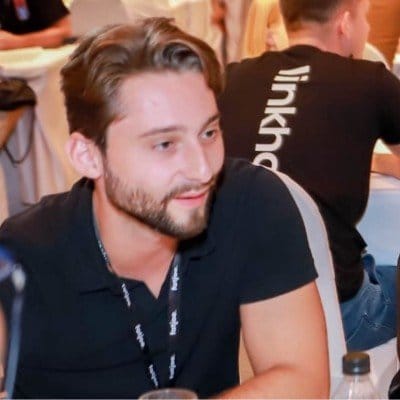 Jeune homme assis en conférence, portant un badge noir