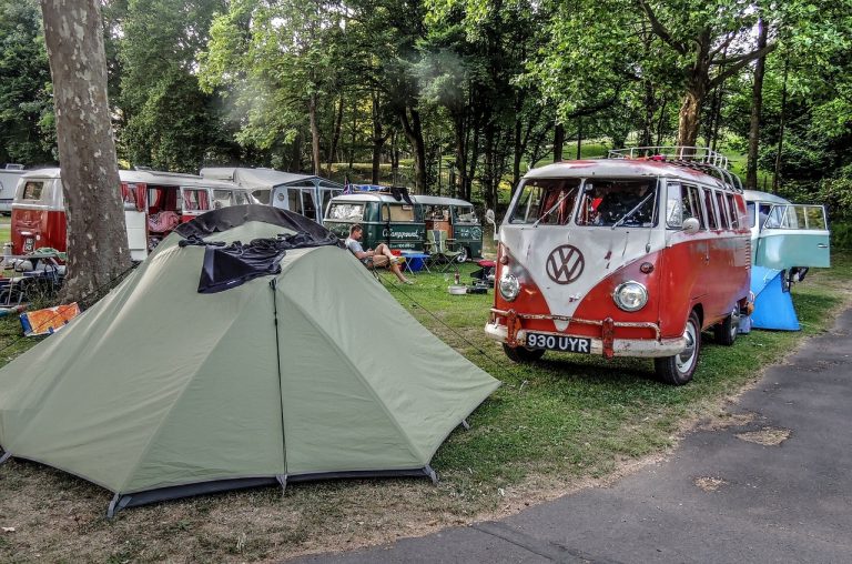 Tente et combis Volkswagen anciens dans un camping arboré