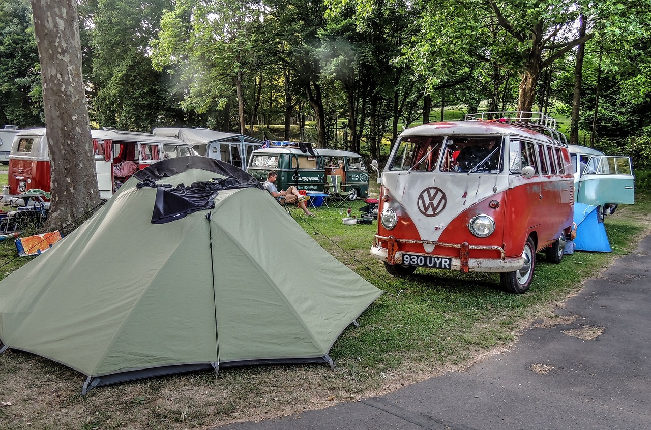 Tente et combis Volkswagen anciens dans un camping arboré