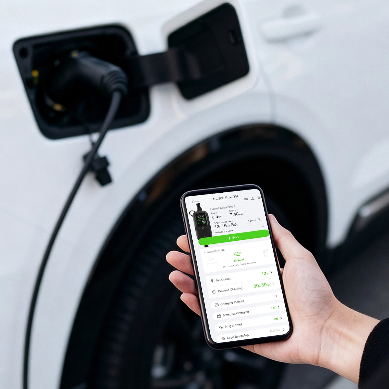 Main tenant un smartphone contrôlant la recharge d’une voiture électrique